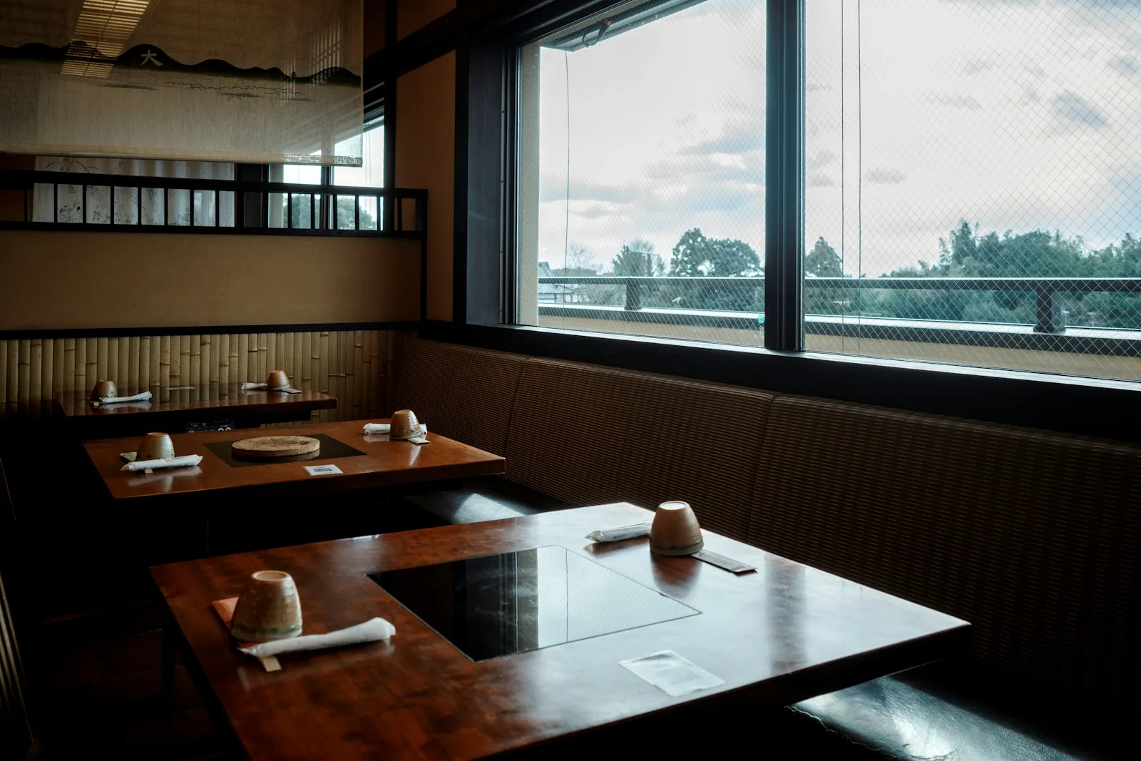 京都の飲食店に並ぶ木のテーブルと湯呑みの写真